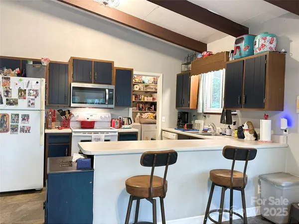 a kitchen with stainless steel appliances kitchen island granite countertop a refrigerator and a stove top oven