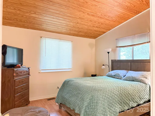 a bedroom with a bed and flat screen tv