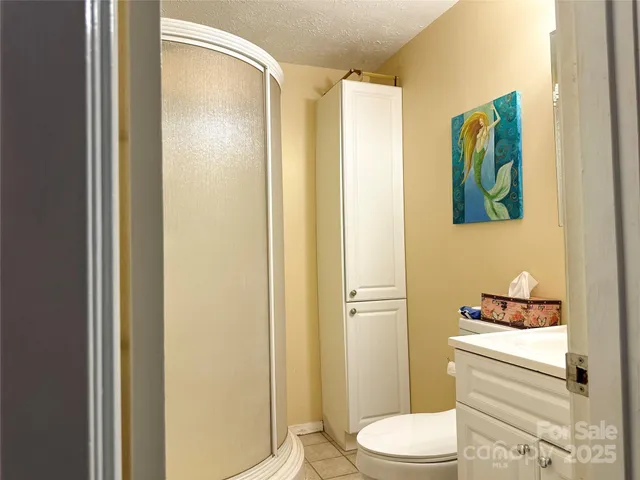 a bathroom with a toilet a sink and glass door