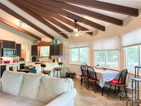a living room with furniture kitchen view and a large window