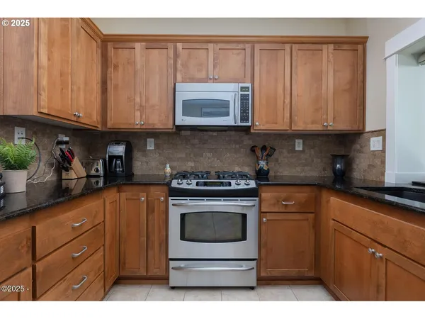 a kitchen with granite countertop a refrigerator and a sink