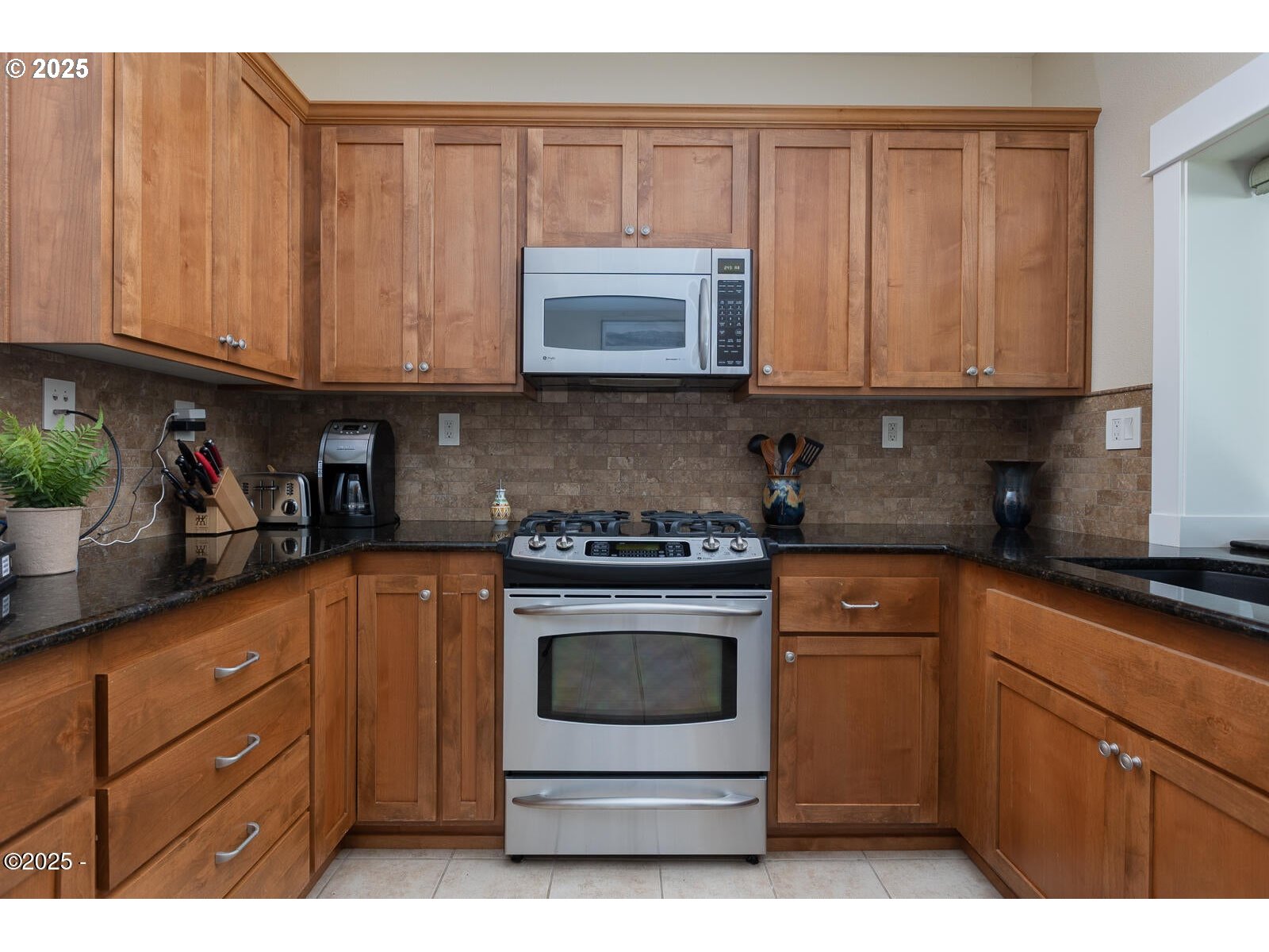 1125 Northwest Spring Street, Unit A302 Newport, OR 97365 - Photo 13 of 31 a kitchen with stainless steel appliances granite countertop a stove a sink and a white cabinets