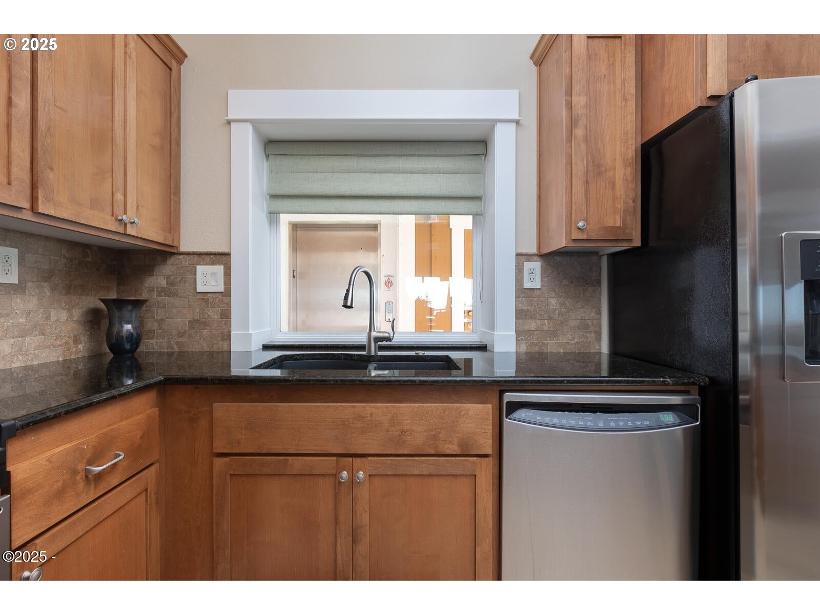 1125 Northwest Spring Street, Unit A302 Newport, OR 97365 - Photo 14 of 31 a kitchen with granite countertop a refrigerator and a sink