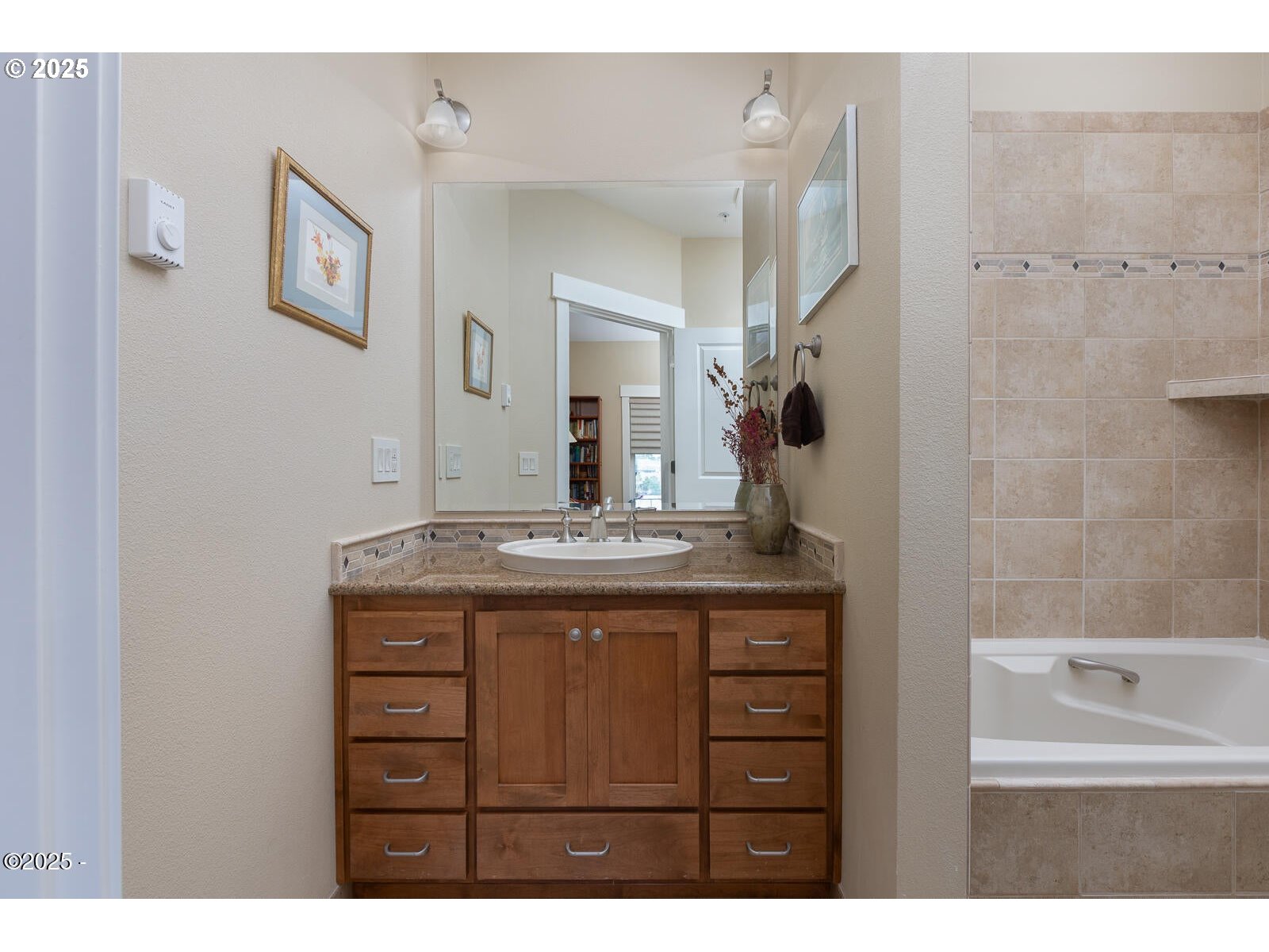 1125 Northwest Spring Street, Unit A302 Newport, OR 97365 - Photo 25 of 31 a bathroom with a granite countertop sink a mirror and shower