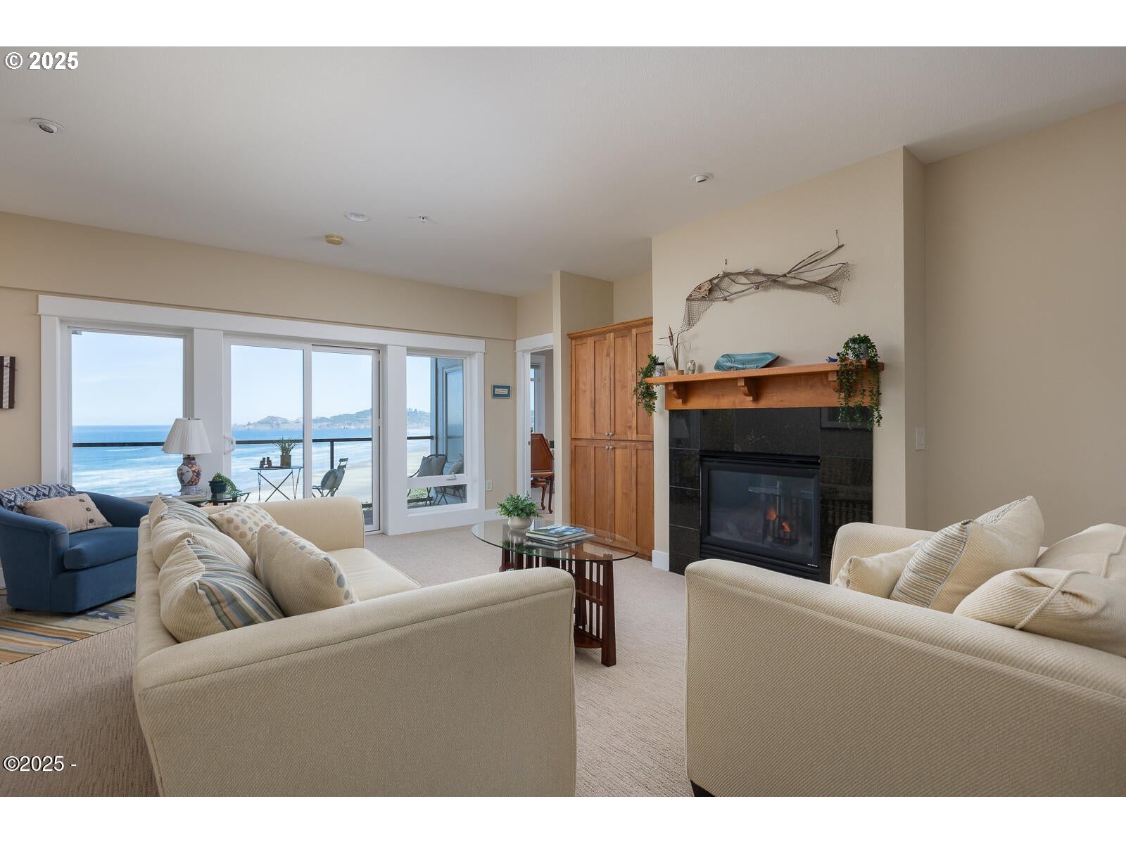 1125 Northwest Spring Street, Unit A302 Newport, OR 97365 - Photo 6 of 31 a living room with furniture a fireplace and a large window