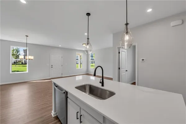 a kitchen with a sink a chandelier and wooden floor