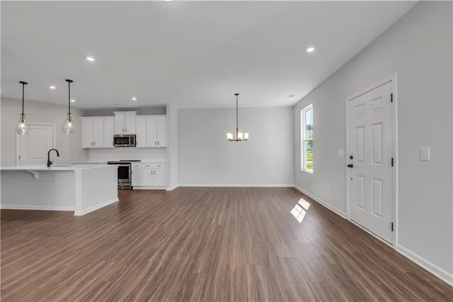 a kitchen with stainless steel appliances granite countertop a sink a stove top oven a counter space and cabinets