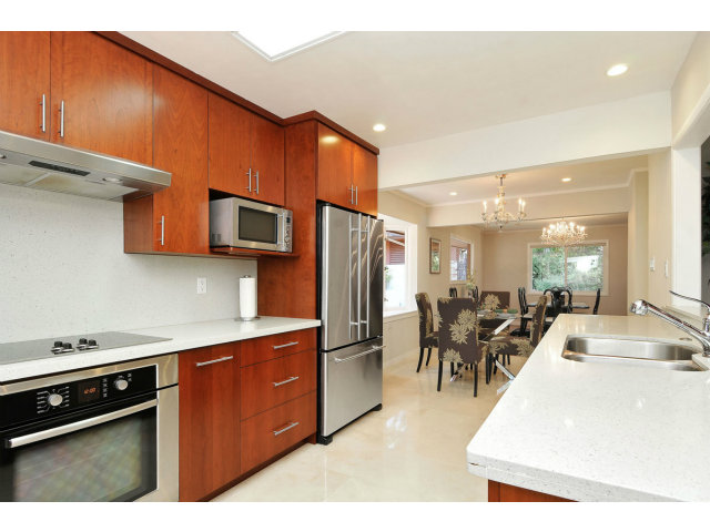 6 Spring Valley Lane Millbrae, CA 94030 - Photo 8 of 25 a kitchen with stainless steel appliances granite countertop a refrigerator a stove top oven a sink dishwasher and dining table with wooden floor