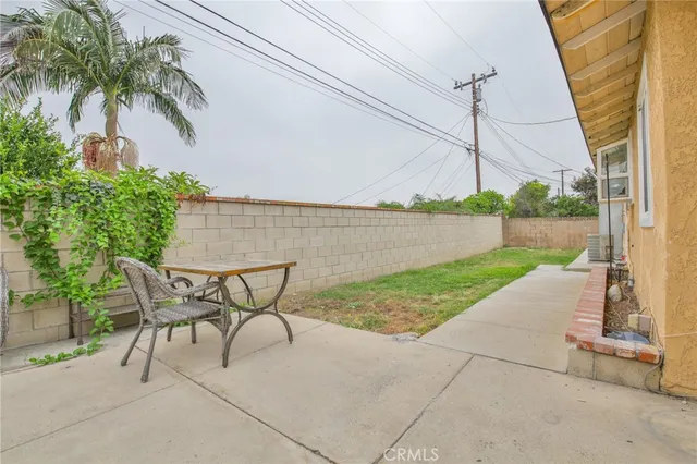 a patio table and chairs with potted plants