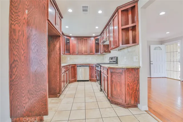 a kitchen with stainless steel appliances granite countertop a refrigerator and a sink