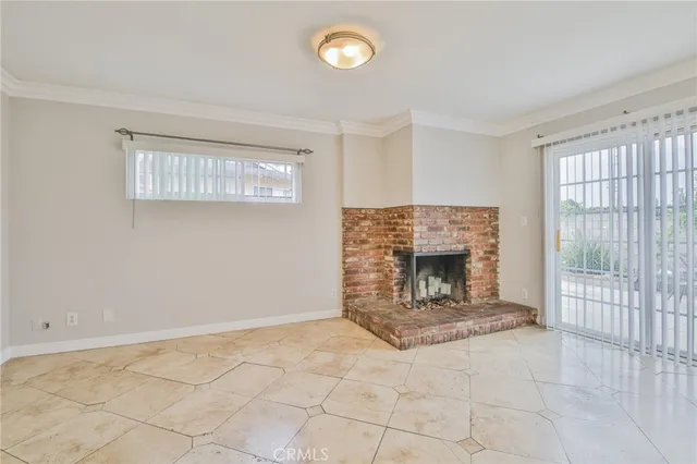 a view of an empty room with a fireplace and a window