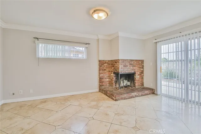 a view of an empty room with a fireplace and a window