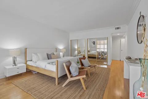 a large bedroom with a bed and wooden floor