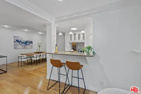 a dining hall with stainless steel appliances granite countertop a granite counter tops and a view of living room