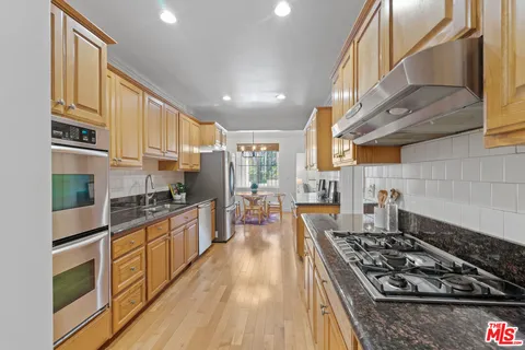 a kitchen with stainless steel appliances granite countertop a stove and a refrigerator