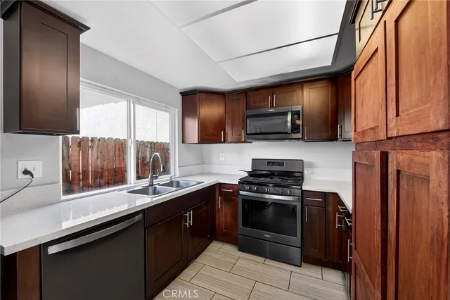 a kitchen with stainless steel appliances a stove sink microwave and cabinets
