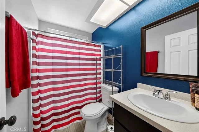 a bathroom with a sink a toilet and shower curtain