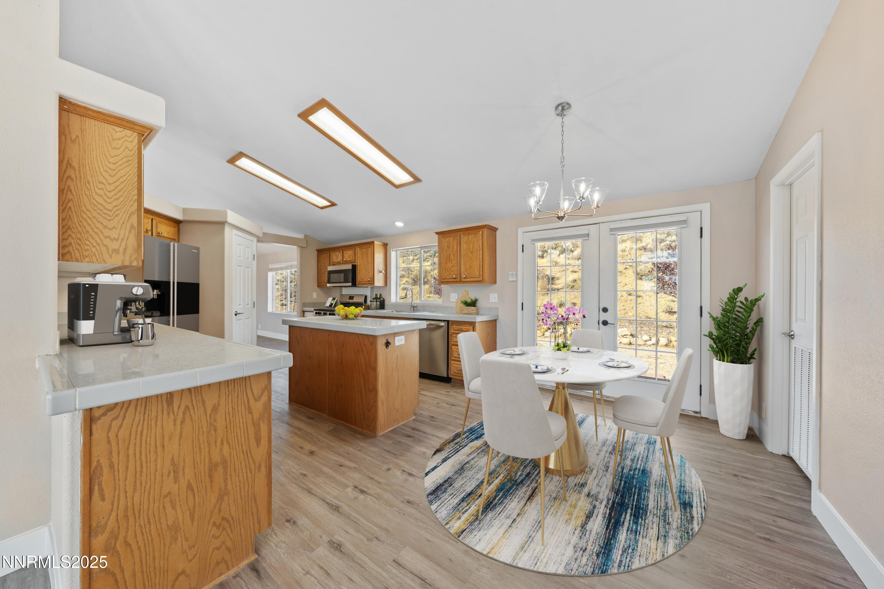 15190 North Red Rock Road Reno, NV 89508 - Photo 17 of 55 a dining room with wooden floor a chandelier a wooden table and chairs
