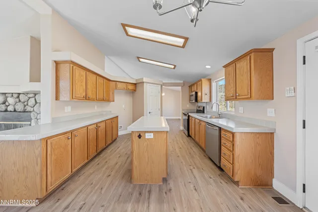 an empty room with wooden floor chandelier and windows