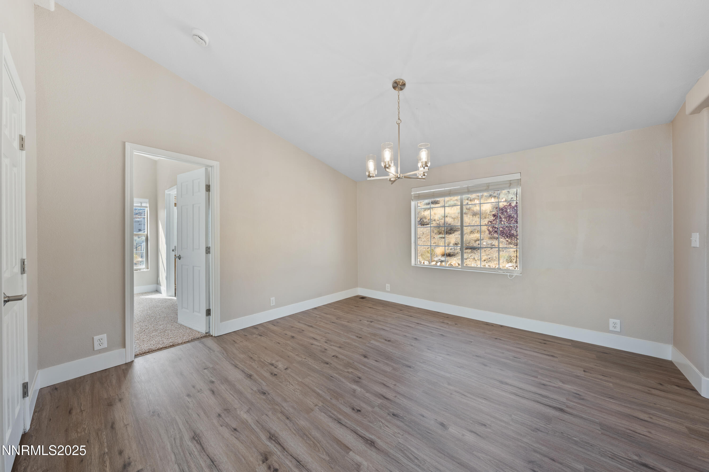 15190 North Red Rock Road Reno, NV 89508 - Photo 29 of 55 an empty room with wooden floor chandelier and windows