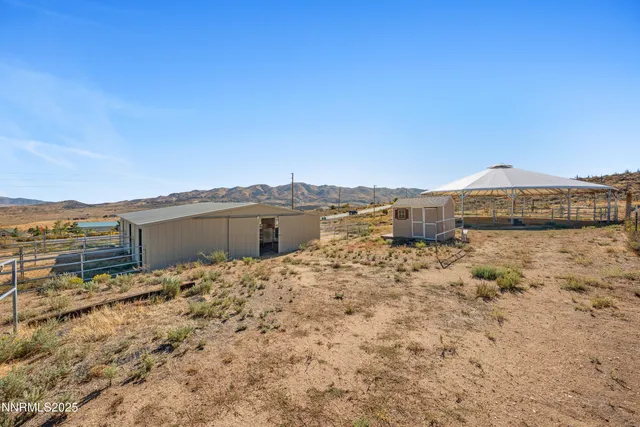 a view of a livingroom with a fireplace a ceiling fan and wooden floor