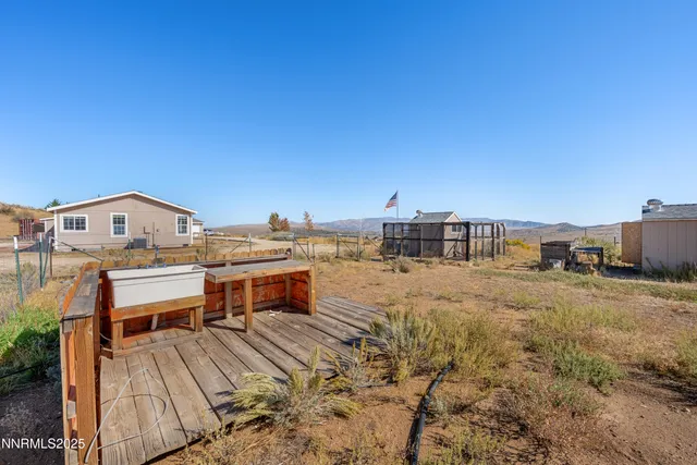 an empty room with wooden floor chandelier fan and windows