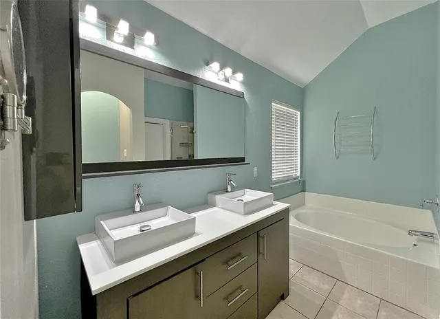 a view of an empty room with wooden floor and a kitchen