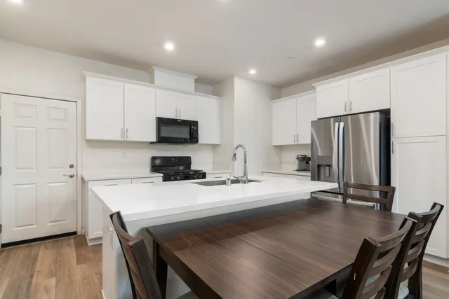 a kitchen with a table chairs refrigerator and microwave