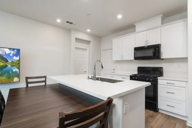a kitchen with a sink a stove and microwave