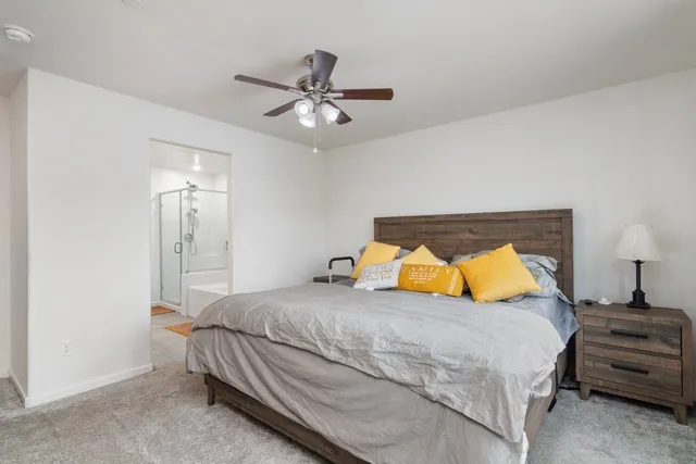 a bedroom with a bed and ceiling fan