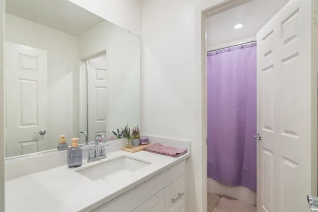 a bathroom with a sink vanity granite tub and shower