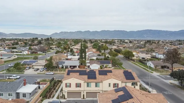 an aerial view of residential houses with outdoor space and parking