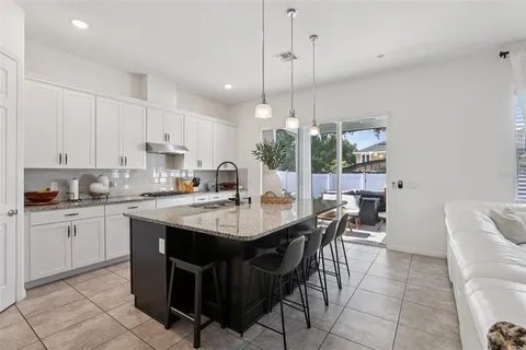 a kitchen with white cabinets and sink