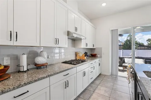 a spacious bedroom with a bed a couch and a large window