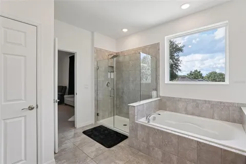 a bed sitting in a bedroom and dresser with wooden floor