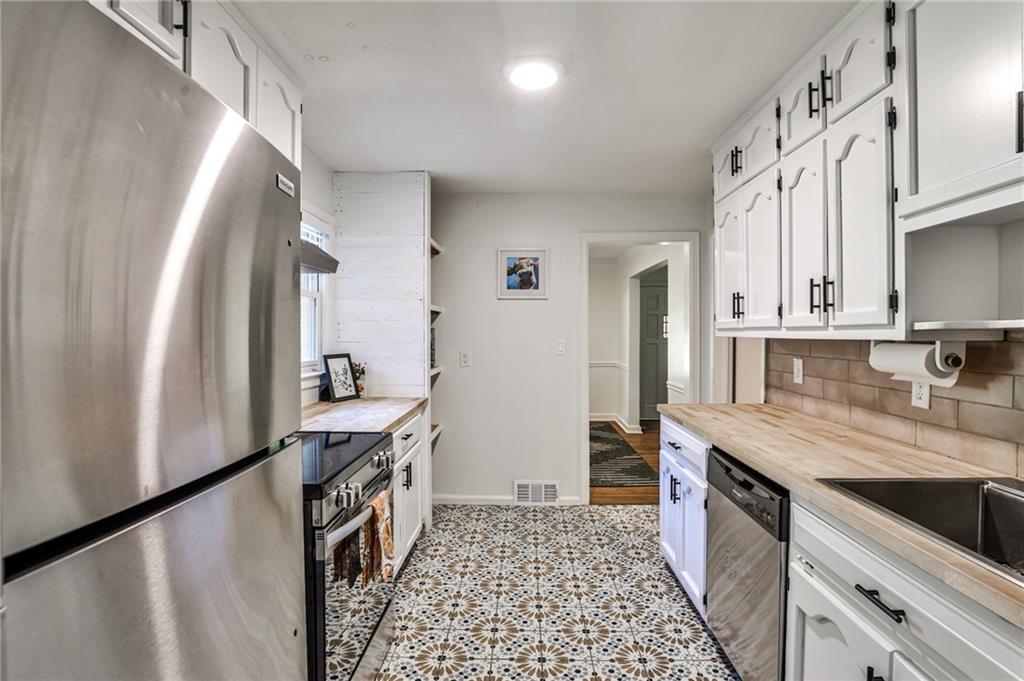 878 Scott Circle Decatur, GA 30033 - Photo 12 of 30 a kitchen with stainless steel appliances granite countertop a sink stove and refrigerator
