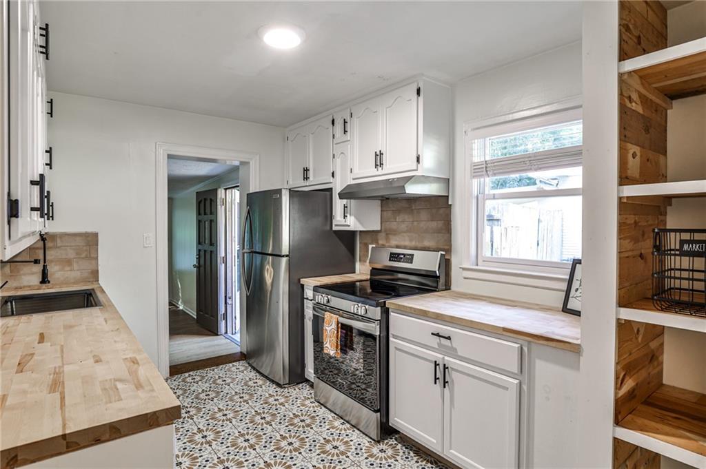 878 Scott Circle Decatur, GA 30033 - Photo 14 of 30 a kitchen with stainless steel appliances granite countertop a stove a refrigerator and a cabinets