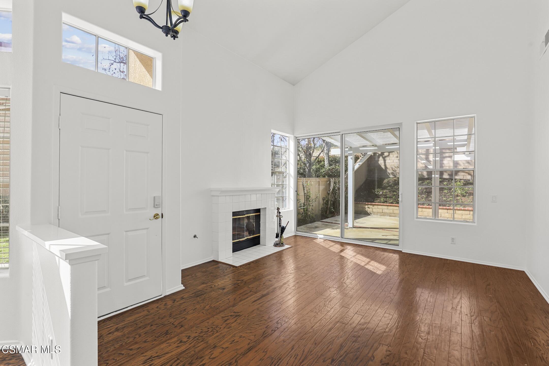 495 Novara Way Oak Park, CA 91377 - Photo 4 of 26 an empty room with wooden floor fireplace and windows