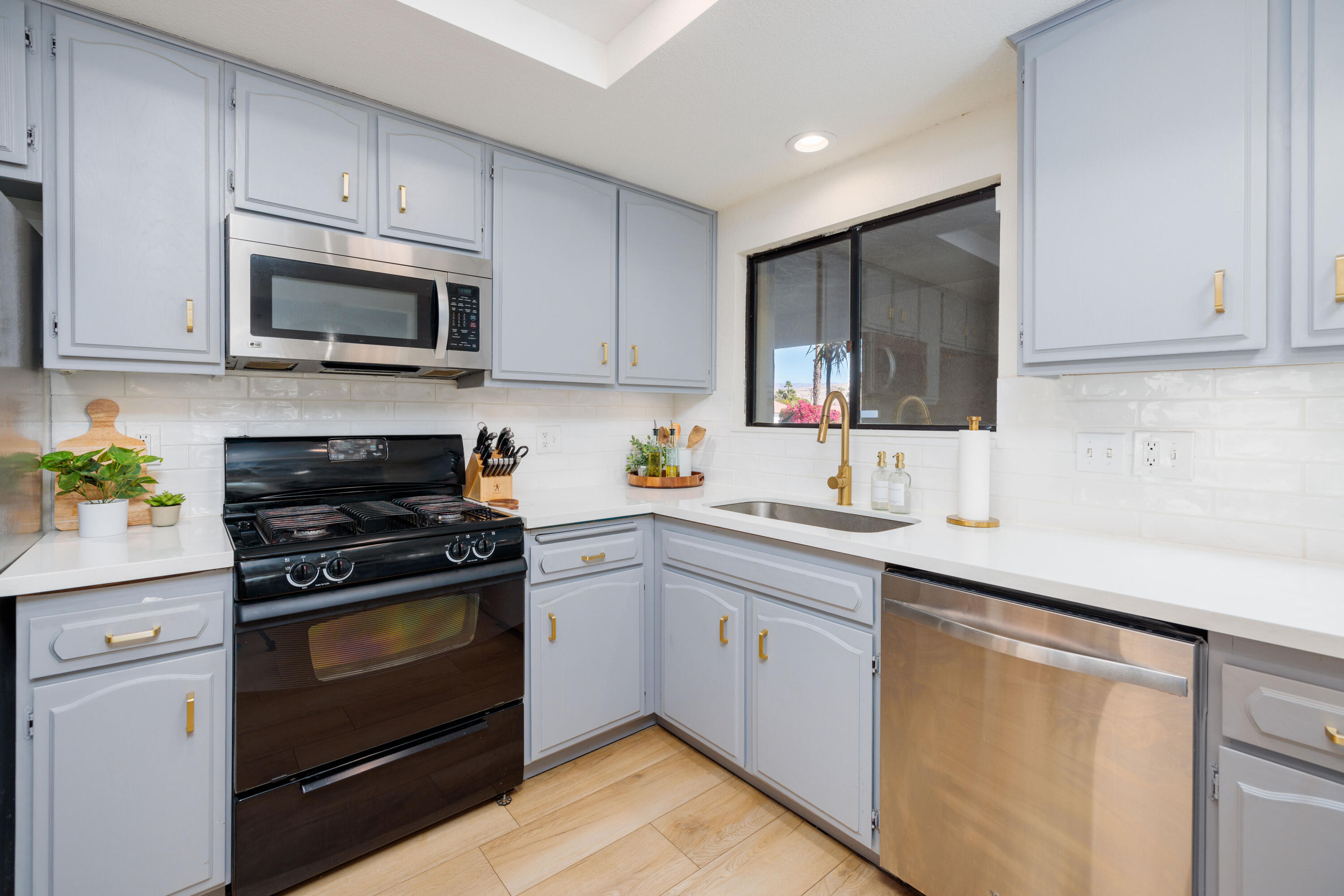 67395 Rango Road Cathedral City, CA 92234 - Photo 12 of 36 a kitchen with white cabinets stainless steel appliances and sink