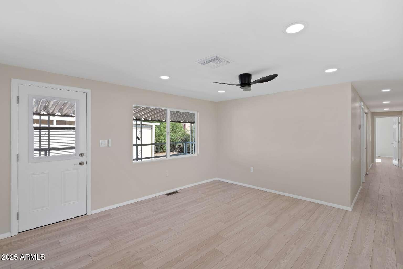 5000 East Grant Road, Unit 203 Tucson, AZ 85712 - Photo 7 of 19 an empty room with wooden floor and windows
