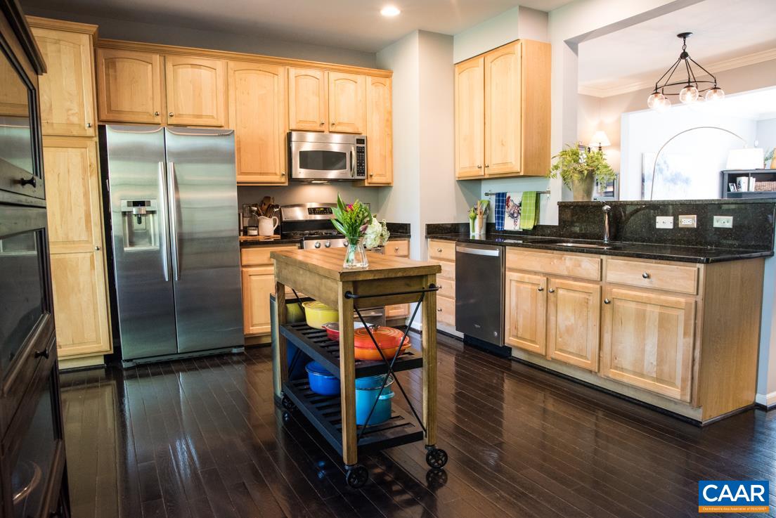 825 Rainier Road Charlottesville, VA 22903 - Photo 11 of 25 a kitchen with stainless steel appliances granite countertop a refrigerator a stove top oven a sink dishwasher and white cabinets with wooden floor