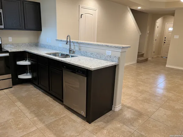 a kitchen with a sink cabinets and wooden floor
