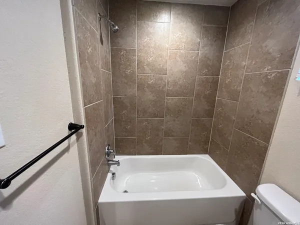 a bathroom with a granite countertop sink and a toilet