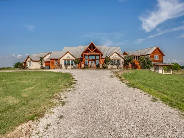 a view of a house with a yard and large trees