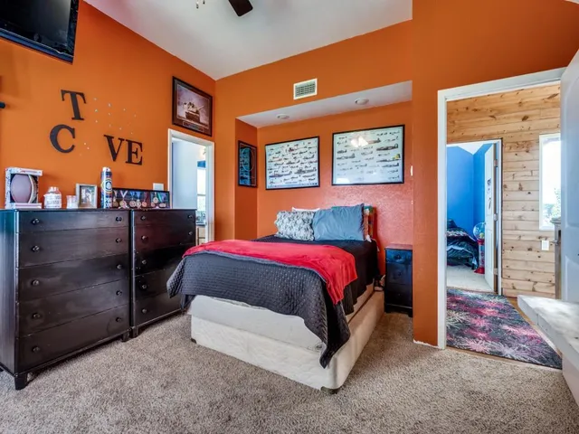 a bathroom with a granite countertop sink a toilet and a window