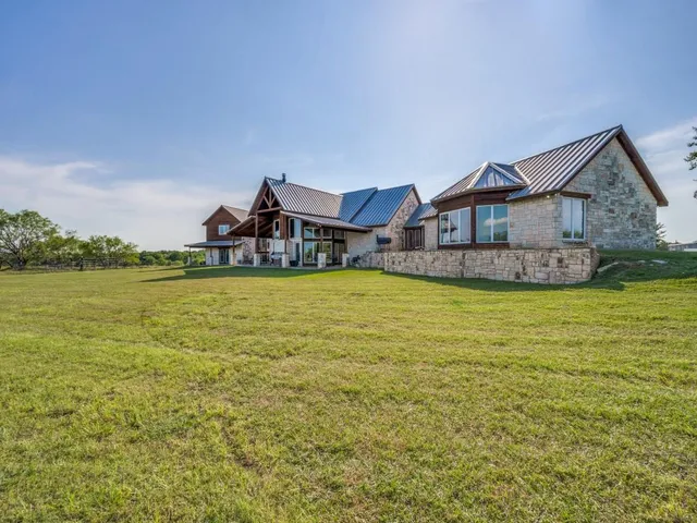 a large house with a large pool and lawn chairs