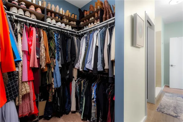 a view of walk in closet with clothes and shoes