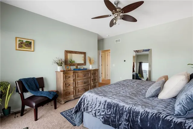 a bedroom with a large bed and a chandelier