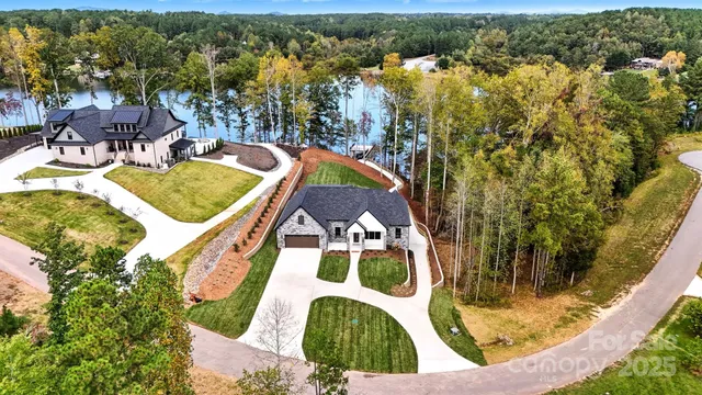 an aerial view of a house with swimming pool and lake view