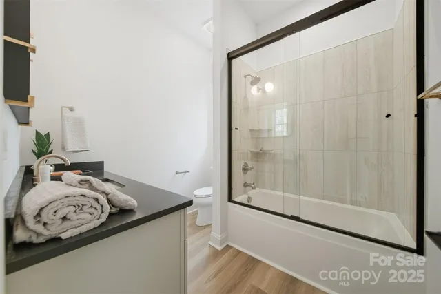 a bathroom with a granite countertop sink a mirror and shower